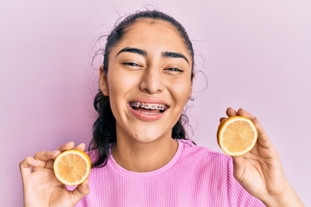 Girl with braces holding lemons